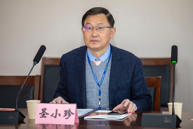 男人拿着笔记本电脑的桌子前  描述已自动生成